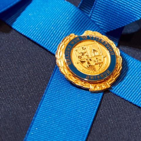 A nursing pin with the UNE crest